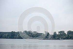 Cargo ship, a barge, cruising on the Danube river in Serbia, in belgrade, carrying construction material.