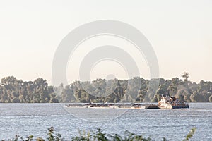 Cargo ship, a barge, cruising on the Danube river in Serbia, in belgrade, carrying construction material, coal, sand and gravel.