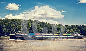 Nákladní loď s kontejnery na řece Dunaj, modrá retro fotografie