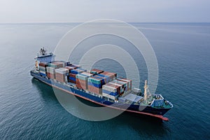 Cargo ship with containers in the open sea, aerial drone view