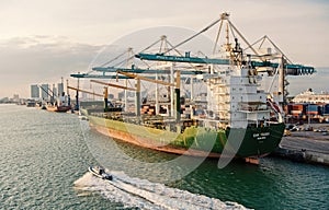 Cargo ship with cranes in sea port. Maritime container port or terminal. Shipping, freight, logistics, merchandise