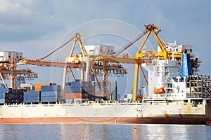 Cargo ship at dock with sky background.