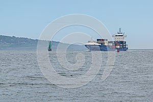 Cargo ship entering Dublin harbour at Poolbeg lighthouse.