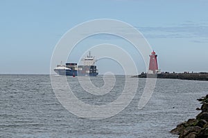 Cargo ship entering Dublin harbour at Poolbeg lighthouse.