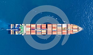 Cargo ship full loaded with containers, blue sea background, top view