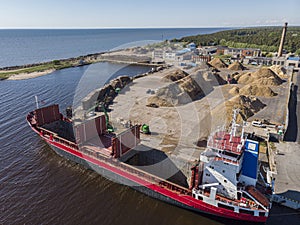 Cargo ship getting load with firewood