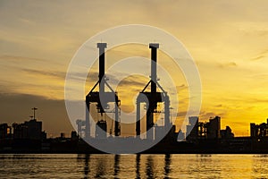 Cargo ship in the harbor at sunset. Large container unloaded