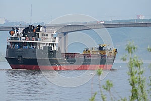 Cargo ship, a large ship is on the river, the passage under the bridge.