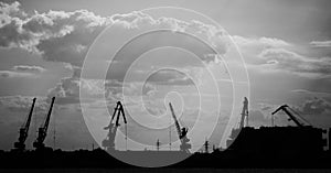 Cargo ship-lifting cranes on the river in the port black-and-white photo