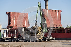 The cargo ship is loaded with firewood from the truck