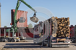 The cargo ship is loaded with firewood from the truck