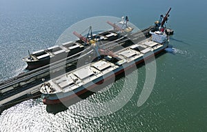 Cargo ship loading in coal cargo terminal