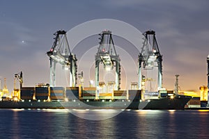 Cargo ship loading cargo container with crane at port