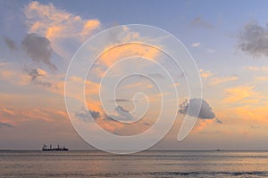 Cargo ship in ocean at sunset