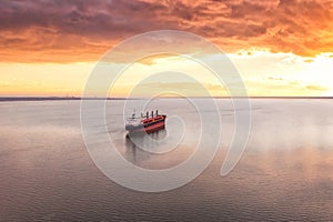 Cargo ship in the open sea at the beautiful sunset. Aerial top view.Shipping. Grain export