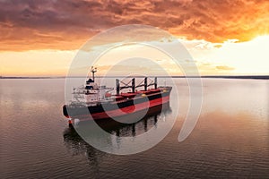 Cargo ship in the open sea at the beautiful sunset. Aerial top view.Shipping. Grain export