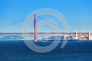 Cargo ship passing under Golden Gate Bridge, USA