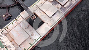 Cargo ship in the process of loading minerals from a mine for export