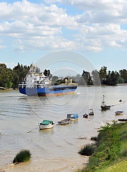 Cargo ship on the river Guadalquivir in its passage through Coria del RÃ­o, Sevilla, AndalucÃ­a, Spain