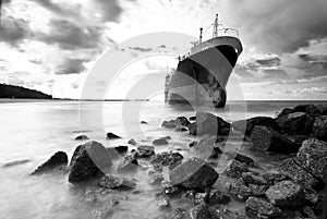 Cargo ship run aground on rocky shore shore
