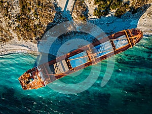 Cargo ship run aground at sea coastline. Shipwreck accident of nautical vessel after huge sea storm, aerial view