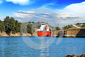 Cargo ship sails between the rocks of the Corinth Canal, Peloponnese, Greece