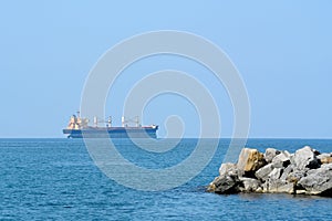 Cargo ship at sea in sunlight