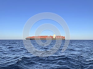 Cargo ship on the sea under clear blue sky