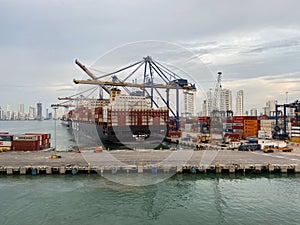 A cargo ship and shipping containers on a dock early in the morning at port in Cartagena, Columbia