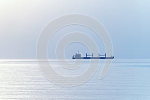 Cargo ship silhouette at horizon