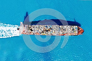 Cargo ship transports containers of garbage for recycling factory. Concept of pollution environment and ocean
