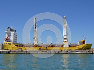 Cargo Ship Under Maintenance at a Shipyard with Two High Cranes