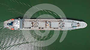 Cargo ship visible from above sailing through the waters of Panama canal strait. Gray ship, drone aerial view from directly above