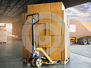 Cargo shipment boxes. Freight truck. Delivery service. Stack of package boxes on pallet with hand pallet truck.