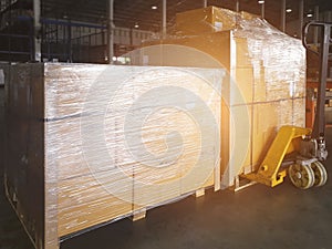 Cargo shipment boxes. Stacked of cardboard boxes wrapping plastic film on pallet rack. Warehouse storage.