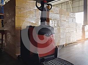 Cargo shipment boxes, Warehousing, Electric forklift pallet jack with stack of cargo boxes on pallet in the warehouse storage.