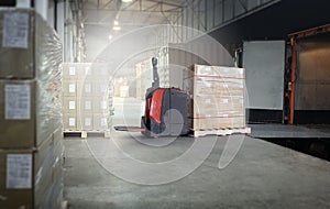 Cargo shipment loading for truck. Electric forklift pallet jack loading heavy cargo pallet into container truck. dock warehouse.