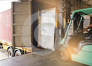 Cargo shipment loading for truck. forklift driver loading cargo pallet shipment with container truck at dock warehouse.