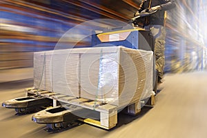 Cargo shipment, Warehousing storage. Motion speed blur of warehouse worker working with forklift pallet jack.