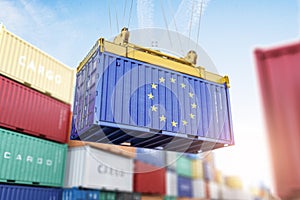 Cargo shipping container with EU European Union flag in a port harbor. Production, delivery, shipping and freight transportation