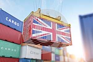 Cargo shipping container with UK United Kingdom flag in a port harbor. Production, delivery, shipping and freight transportation