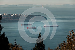 Cargo ships anchored in Burrard Inlet near Point Grey in Vancouver, BC.