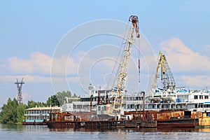 Cargo ships and carnes for loading on river at summer photo
