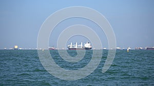 Cargo ships floats on waves in the blue sea