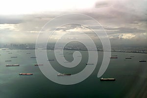 Cargo ships in the port of Singapore. View from above. Aerial view to the shore and sea from the plane