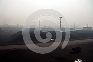 Cargo terminal for discharging coal cargos by shore cranes during foggy weather. Port Bayuquan,China. photo