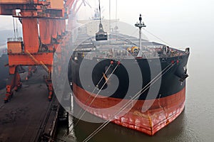 Cargo terminal for discharging coal cargos by shore cranes during foggy weather. Port Bayuquan,China. photo