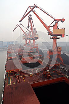 Cargo terminal for discharging coal cargos by shore cranes during foggy weather. Port Bayuquan,China. photo