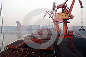 Cargo terminal for discharging coal cargos by shore cranes during foggy weather. Port Bayuquan,China. photo