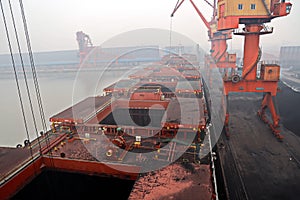 Cargo terminal for discharging coal cargos by shore cranes during foggy weather. Port Bayuquan,China. photo